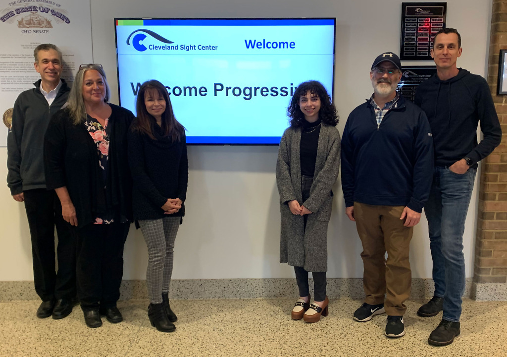 A group picture of six team members standing in front of the Cleveland Sight Center welcome sign.